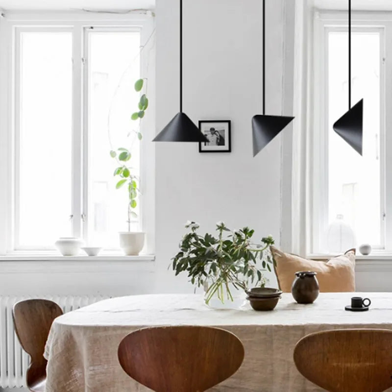 Minimalist A.T.I.A. Pendant Light pair suspended above a dining table, the conical black shades delivering focused illumination with timeless modern appeal, from Domus Collective curated pendant collection.
