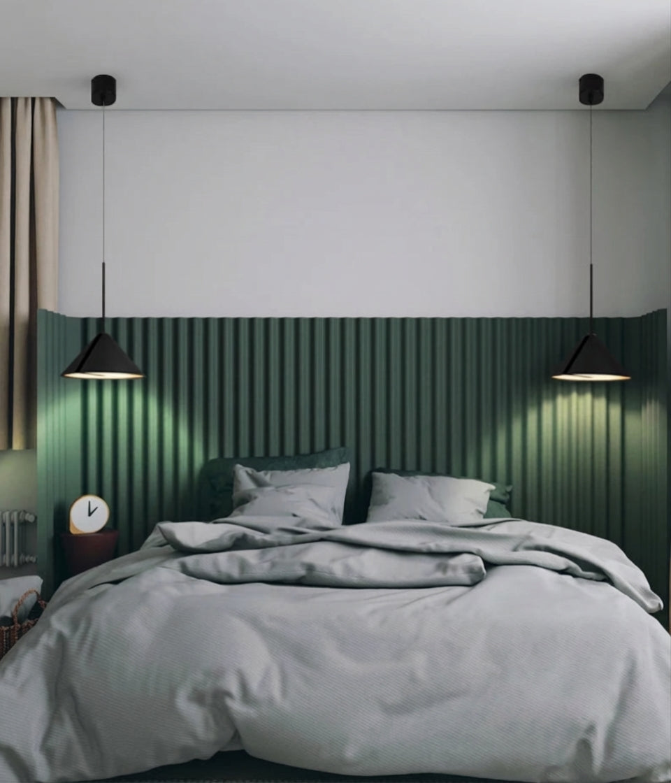Domus Collective A.T.I.A. Pendant Light flanking a sophisticated bedroom with ribbed green feature wall, the suspended conical forms creating characterful bedside lighting with warm directional glow.
