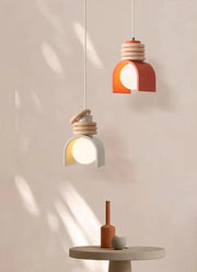 Two Arc of Calm Pendant Lights in terracotta and grey with sculptural ceramic forms suspended at different heights,curated lighting from Domus Collective.