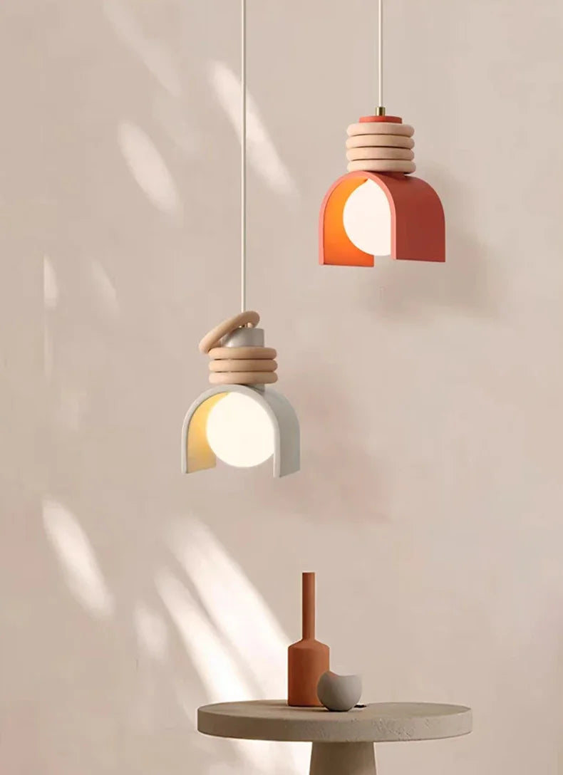 Two Arc of Calm Pendant Lights in terracotta and grey with sculptural ceramic forms suspended at different heights,curated lighting from Domus Collective.