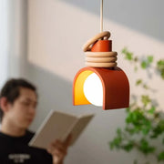 Arc of Calm Pendant Light in warm terracotta with stacked ceramic rings creating soulful ambient glow for contemporary reading nooks,Domus Collective Organic Accents collection.