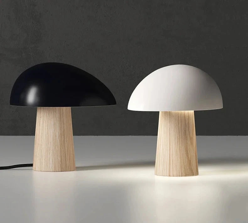Two mushroom-shaped table lamps, one black and one white, on a dark background.