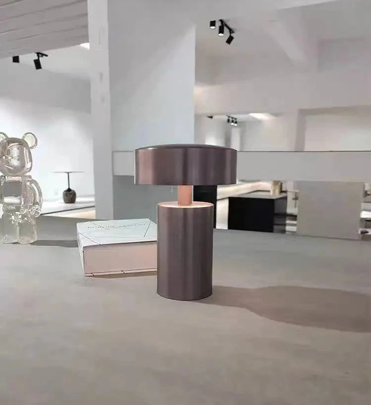 Cologne Halo Night Portable Light in brown iron finish displayed in a contemporary gallery space, its warm copper-toned glow and floating disc design bringing sculptural elegance to modern environments, by Domus Collective.