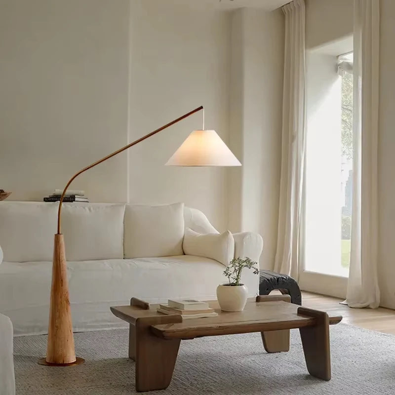 Serene Driftwood Reel Floor Lamp in natural wood with copper-toned arm and linen shade in light-filled minimalist interior,a Domus Collective artisanal floor lighting embodying tranquility and timeless appeal.
