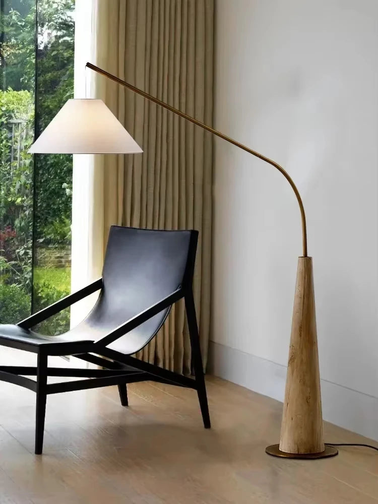Driftwood Reel Floor Lamp by Domus Collective with sculptural blonde wood conical base and arched brass arm supporting linen cone shade ,organic floor lighting bringing natural warmth to contemporary Australian interiors.
