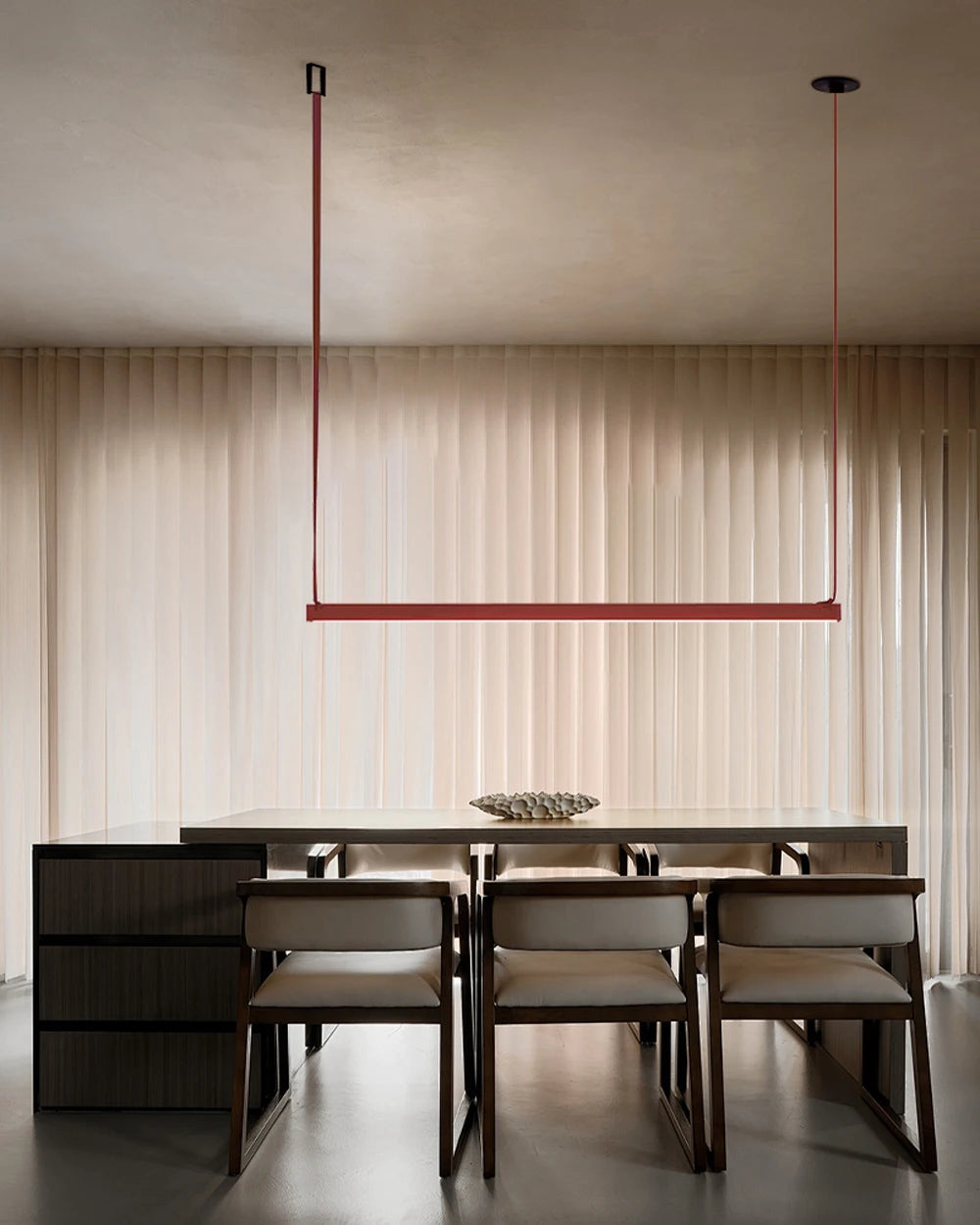 A single Orange bar EmDash Suspension Light in polished steel, its bold linear frame grounding a warm, textural dining room with quiet confidence - a distinctive statement pendant that defines the heart of a sophisticated contemporary interior by Domus Collective.