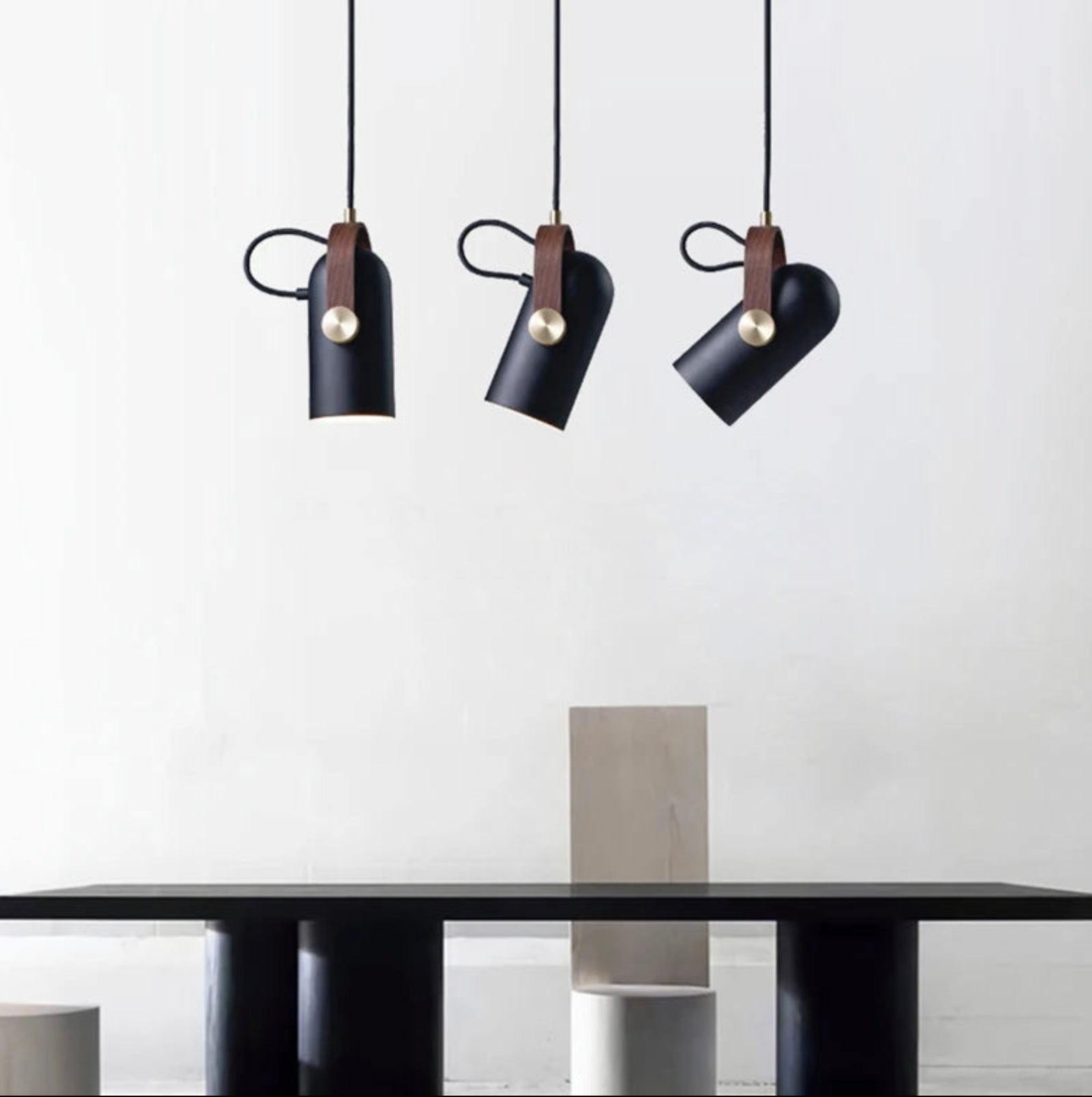 Trio of Film Projector Pendant Lights in matte black finish with brass hardware and walnut straps, curated adjustable spotlights for contemporary dining and gallery spaces, by Domus Collective.