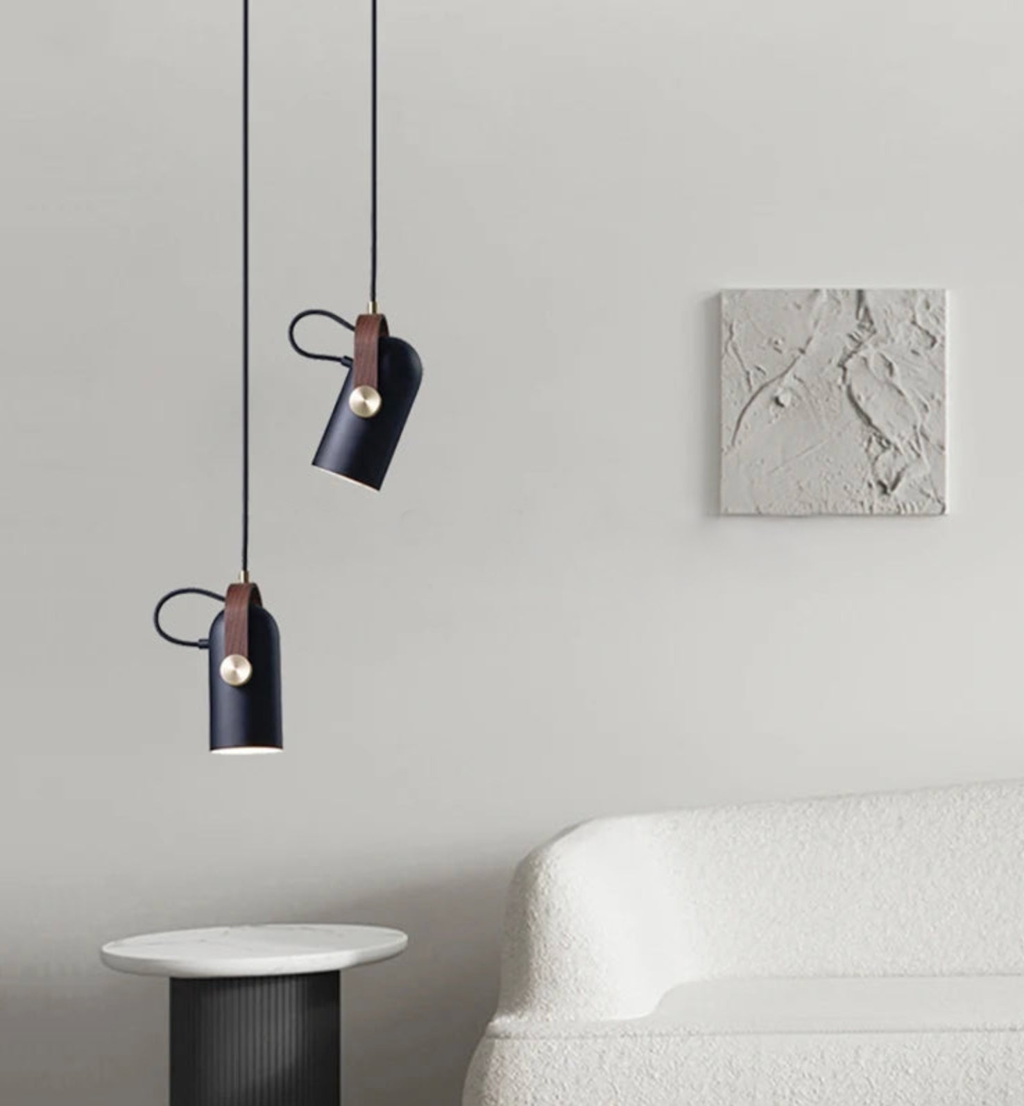 Dual Film Projector Pendant Lights in navy black with warm wood accents suspended beside bouclé sofa, refined cinema-style lighting for curated contemporary lounges, by Domus Collective.