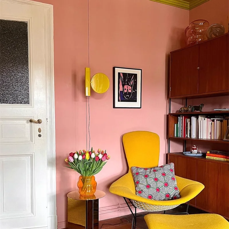 Vibrant yellow Floating Disc  Suspension Lights with glossy metal finish adds a playful pop of color to an eclectic living space, curated home lighting by Domus Collective.