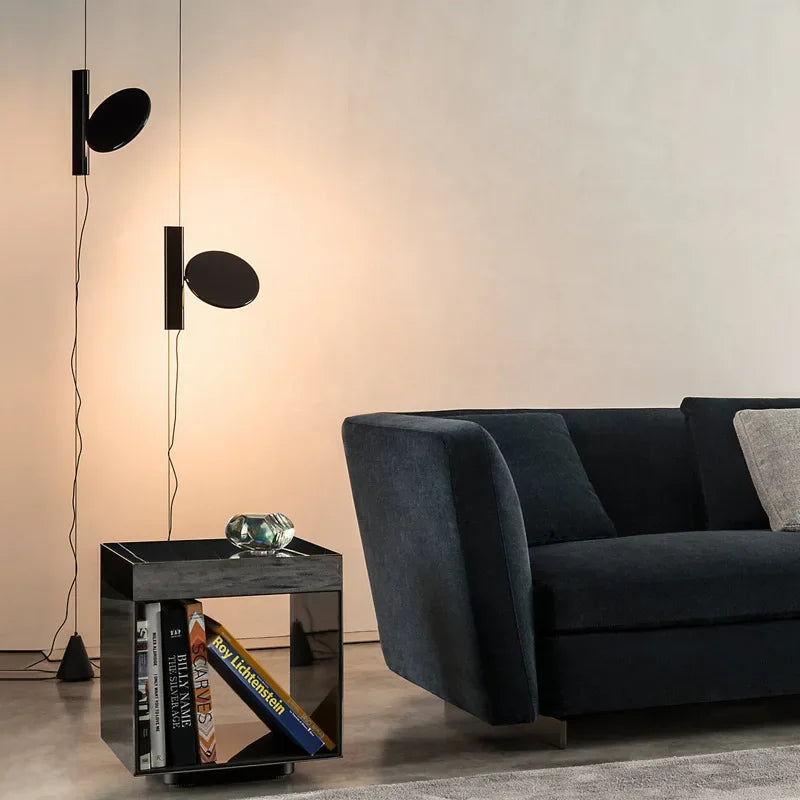 Two matte black Floating Disc  Suspension Lights creating layered ambient lighting beside a contemporary sofa, designer home illumination by Domus Collective.