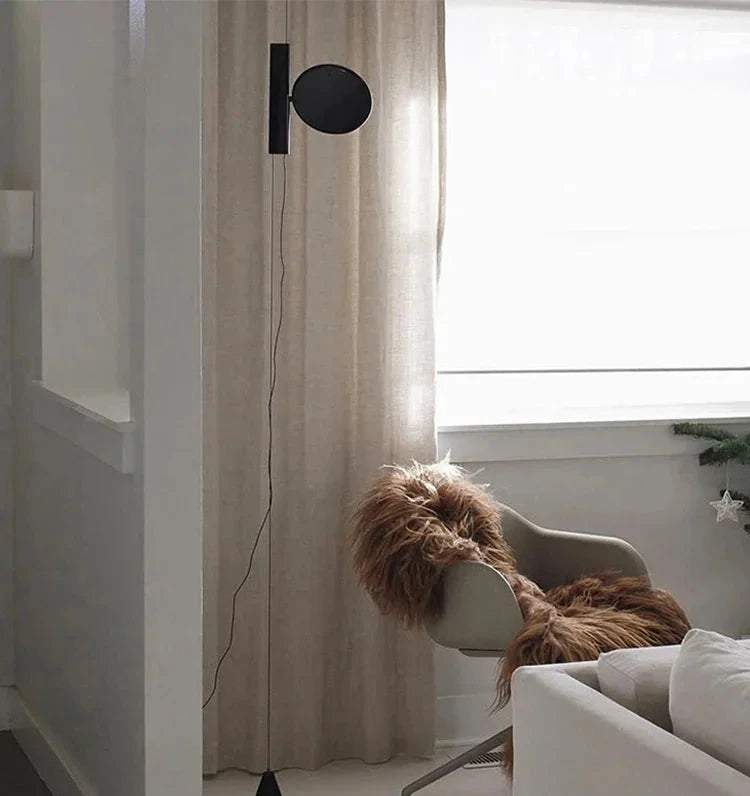 Floating Disc  Suspension Lights in matte black bringing understated elegance to a serene Scandinavian reading nook, minimalist luxury by Domus Collective.