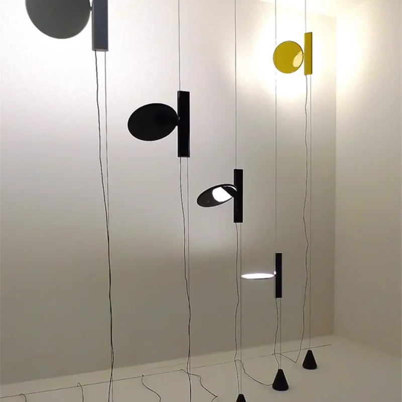 Sculptural  Suspension Lights with circular disc shades in black and yellow finishes suspended at varying heights, modern designer lighting by Domus Collective.