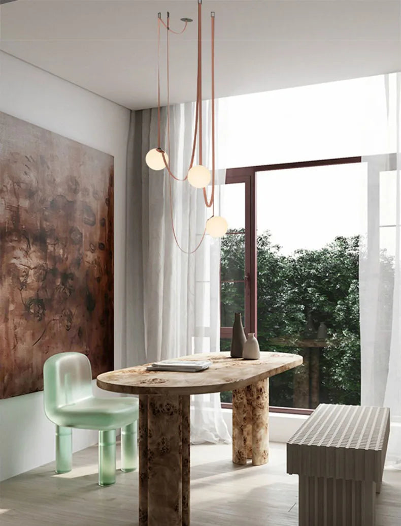 Three-globe Floating Moons Pendant Light on terracotta cords above artisan dining table, refined sculptural fixture for eclectic modern interiors, by Domus Collective.