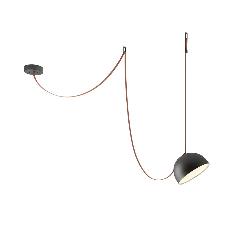 Matte black Hemisphere Suspension Light on terracotta leather cord against white backdrop, showcasing artisan construction and minimalist dome silhouette, by Domus Collective.