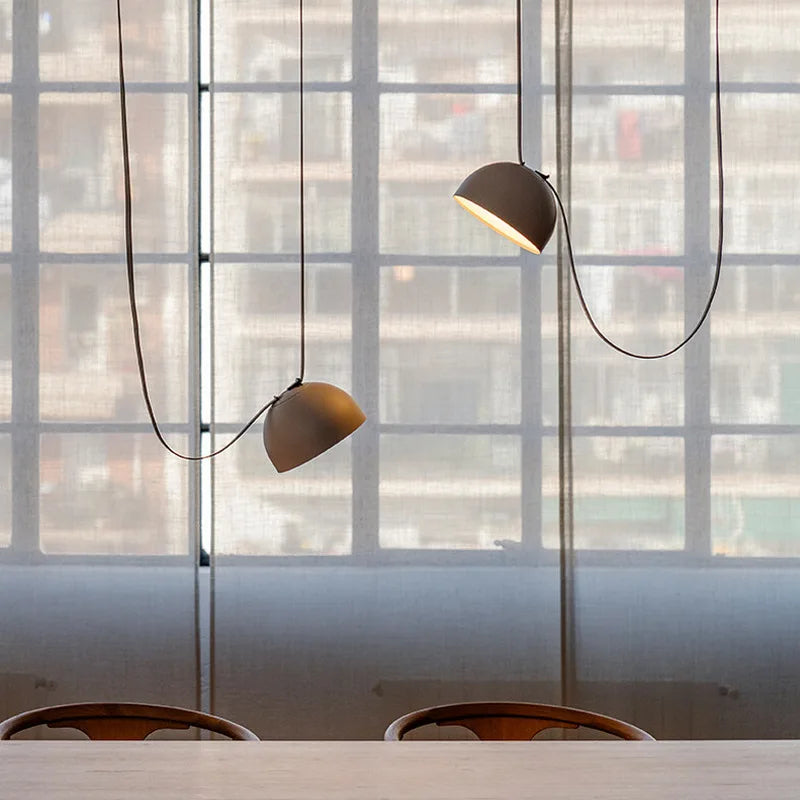 Artisan-designed Hemisphere Suspension Light featuring dual gray dome shades with swooping cord silhouette, curated pendant lighting for contemporary dining spaces, by Domus Collective.
