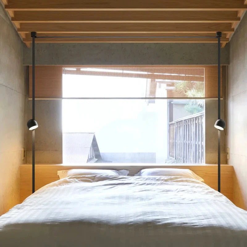 Minimalist matte black Hemisphere Suspension Light pair flanking a bed as modern reading sconces, crafted for tranquil bedroom ambiance, by Domus Collective.