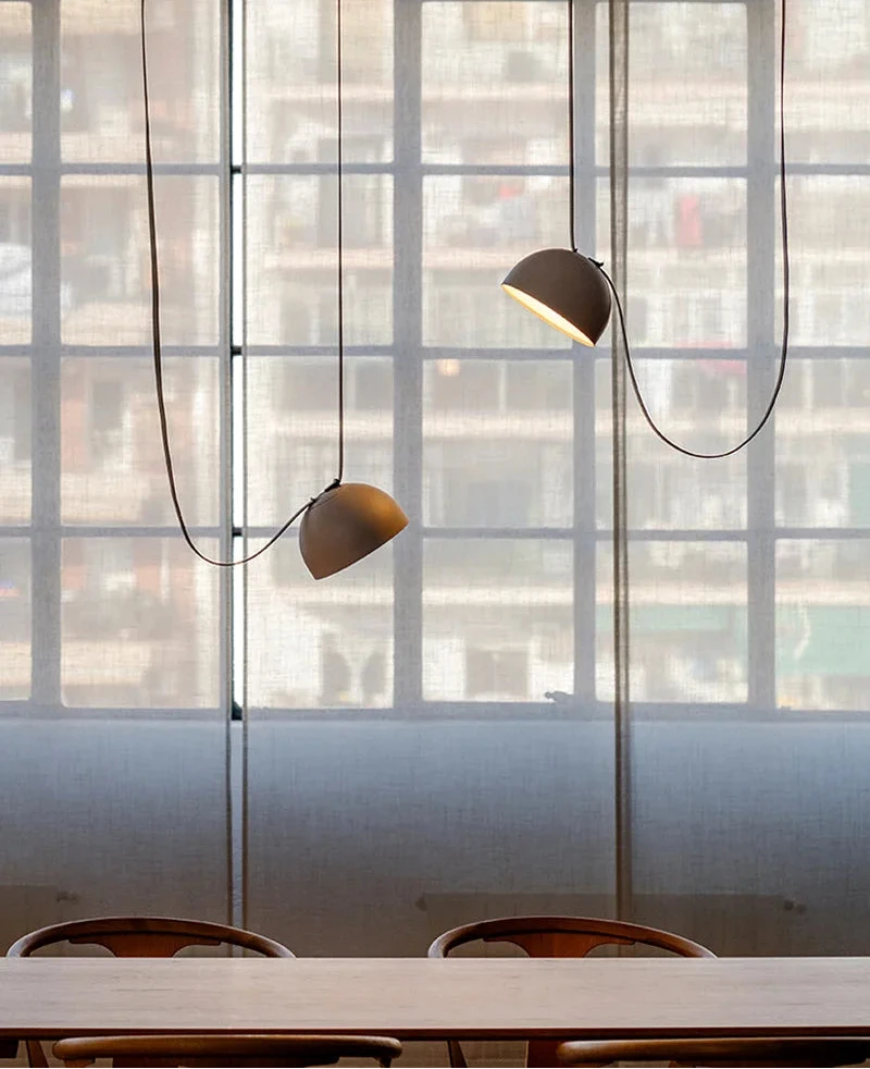 Hemisphere Suspension Light duo in soft gray finish suspended above marble dining table, refined pendant lighting for modern entertaining spaces, by Domus Collective.