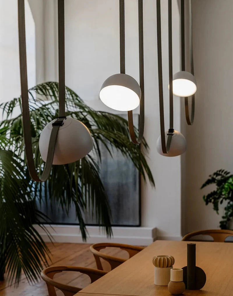 Clustered white Hemisphere Suspension Lights with leather loop detail over oak dining table, curated multi-pendant arrangement for organic modern homes, by Domus Collective.