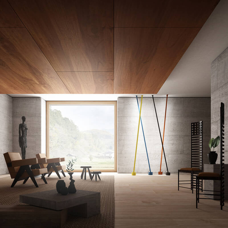 Illuminus Threads Suspension Light in yellow, blue, orange, and black arranged in a sculptural grouping within a concrete and timber gallery space, their colorful linear forms adding contemporary artistry, by Domus Collective.