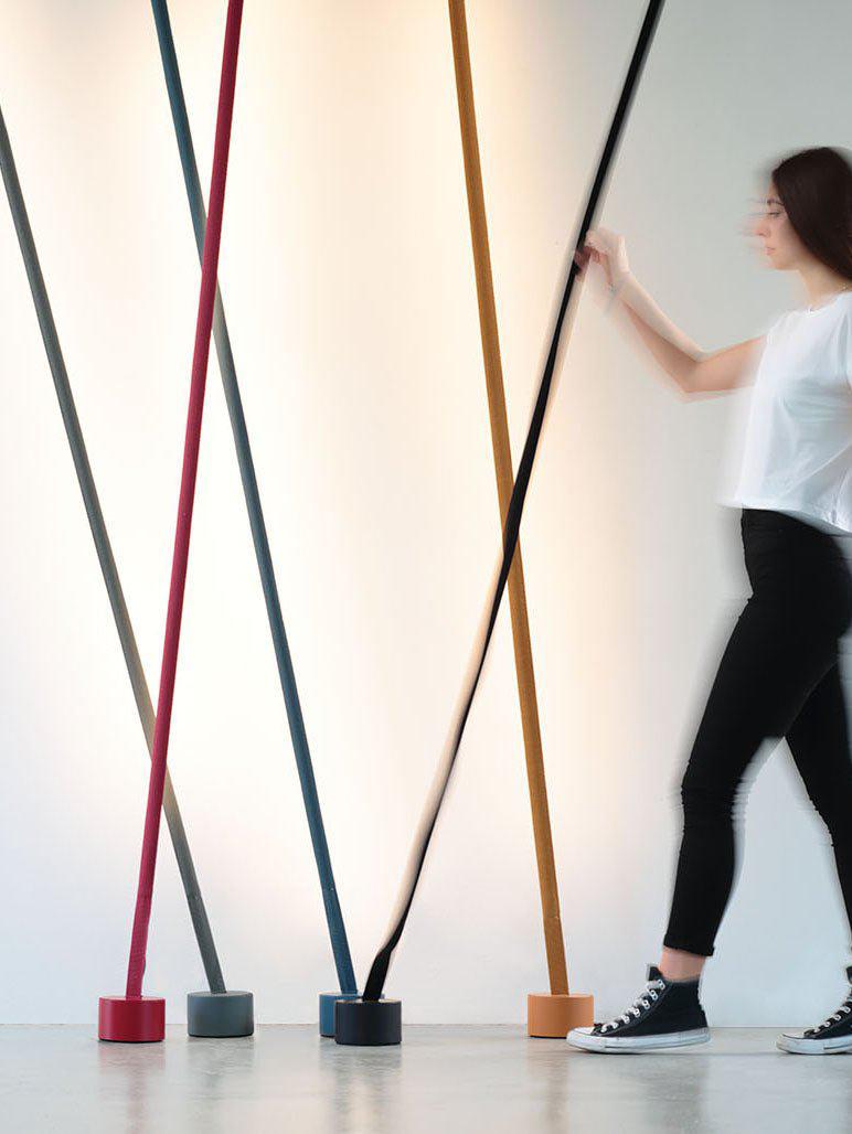 Collection of Illuminus Threads Suspension Light in red, charcoal, mustard, and black demonstrating adjustable positioning, their flexible fabric-wrapped LED tubes enabling creative angular configurations for artistic interiors.