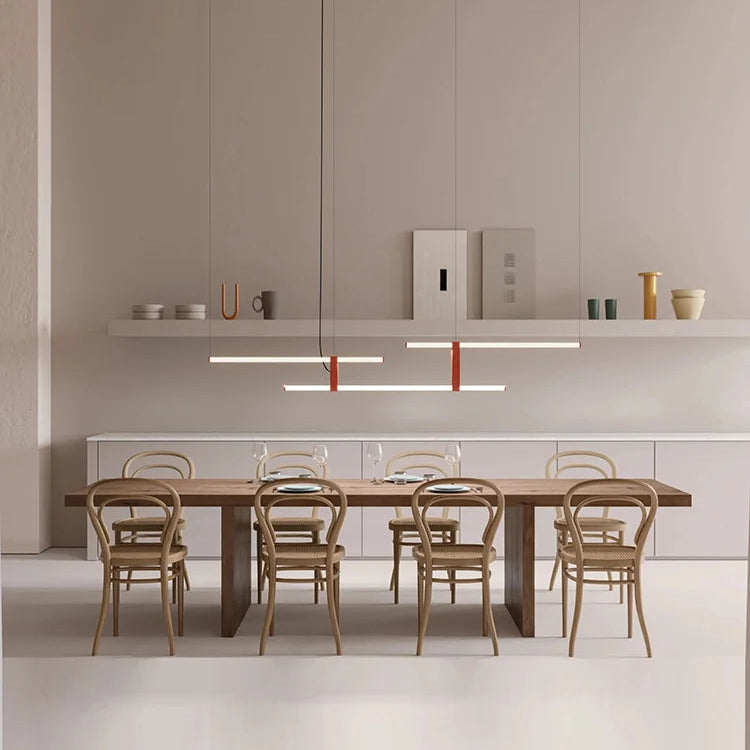 In Parallel Suspension Light in red vegan leather, three lines of light in quiet balance above a long dining table, architectural lighting for a calm, minimalist interior, by Domus Collective.