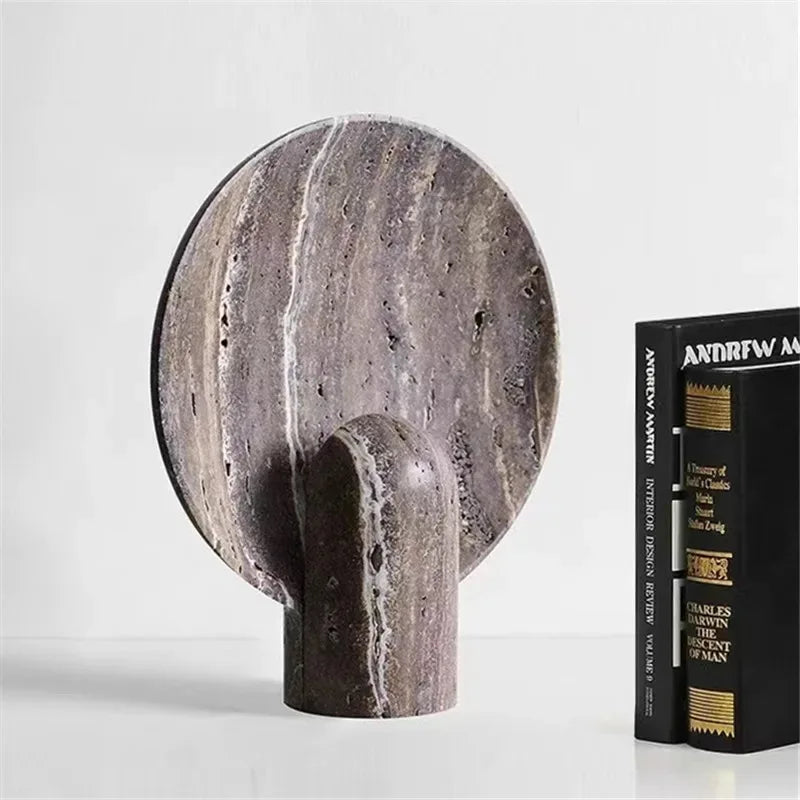 Jupiter Halo Table Lamp in grey-brown travertine displayed unlit, revealing natural stone veining and sculptural circular form with integrated cylindrical base, by Domus Collective.