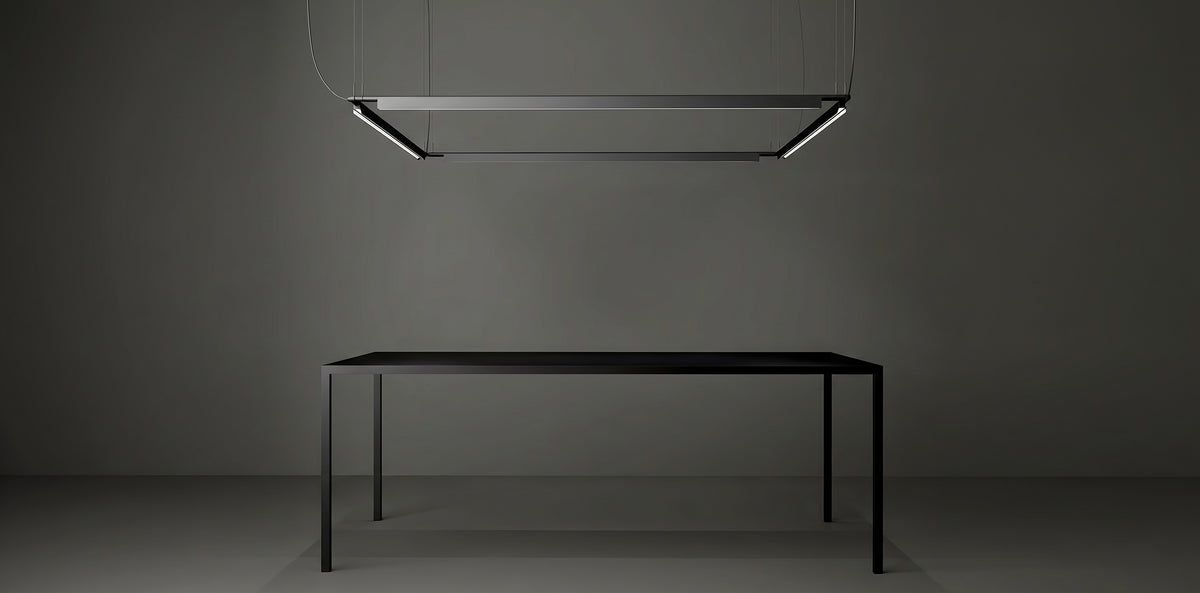 A Lama dell'Architetto Pendant Light by Domus Collective, in black. Four linear pendants joined in a rectangular formation above a long black table, a sculptural workspace lighting installation for meeting rooms and boardrooms.