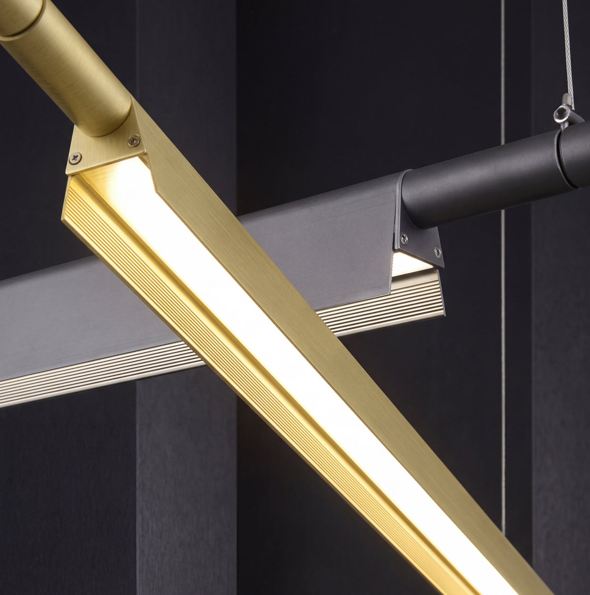 A Lama dell'Architetto Pendant Light by Domus Collective, in gold. A detail of the illuminated diffuser along the underside of the blade, spreading an even glow across a dining table, kitchen island or meeting table.