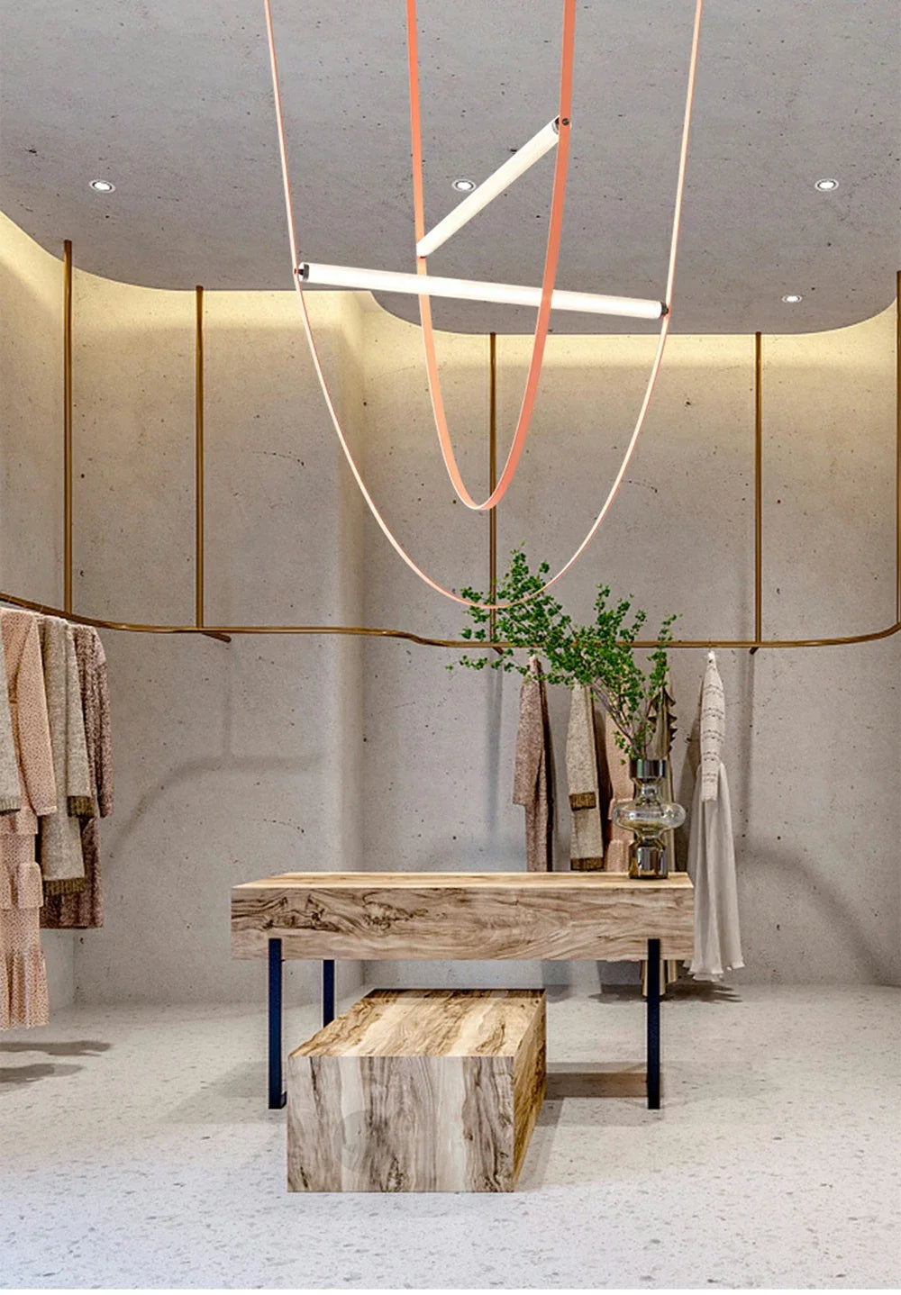 Leather Trapeze Suspension Light in blush leather with crossed LED tubes above designer boutique display, curated pendant fixture creating inviting warmth in contemporary retail environments, by Domus Collective.