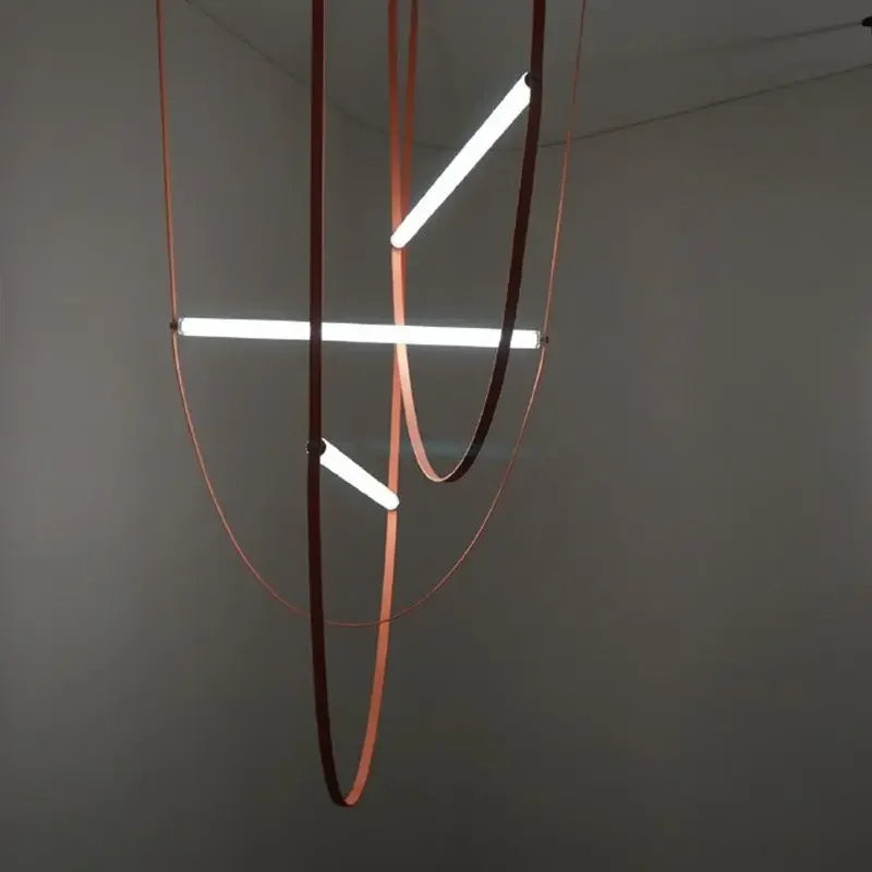 Multi-tiered Leather Trapeze Suspension Lights featuring intersecting LED bars suspended by coral and oxblood leather loops, handcrafted lighting installation blending industrial form with organic texture, by Domus Collective.