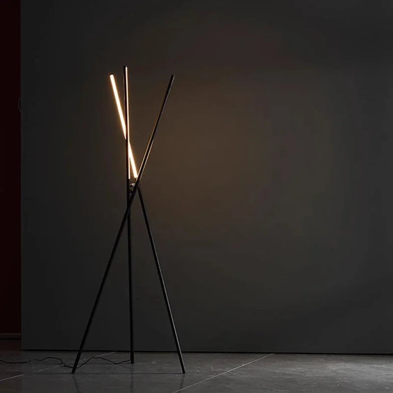 Bold geometric Linear Tension Floor Lamp in matte black with angular crossed frame and linear LED illumination, delivering understated sophistication for minimalist living spaces, by Domus Collective.