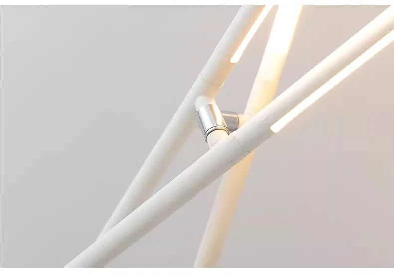 Detail view of the Linear Tension Floor Lamp's polished chrome central joint connecting white powder-coated metal rods with illuminated LED bars, demonstrating refined craftsmanship, by Domus Collective.