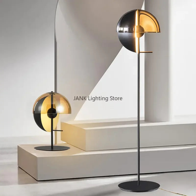 Lunar Visor Floor Lamp paired with matching table lamp version showing coordinated amber and smoked glass spherical designs in gallery setting, curated lighting collection by Domus Collective.