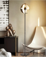 Lunar Visor Floor Lamp with smoked glass globe and warm amber inner diffuser illuminating a sophisticated living room with sculptural bronze decor, designer statement lighting by Domus Collective.