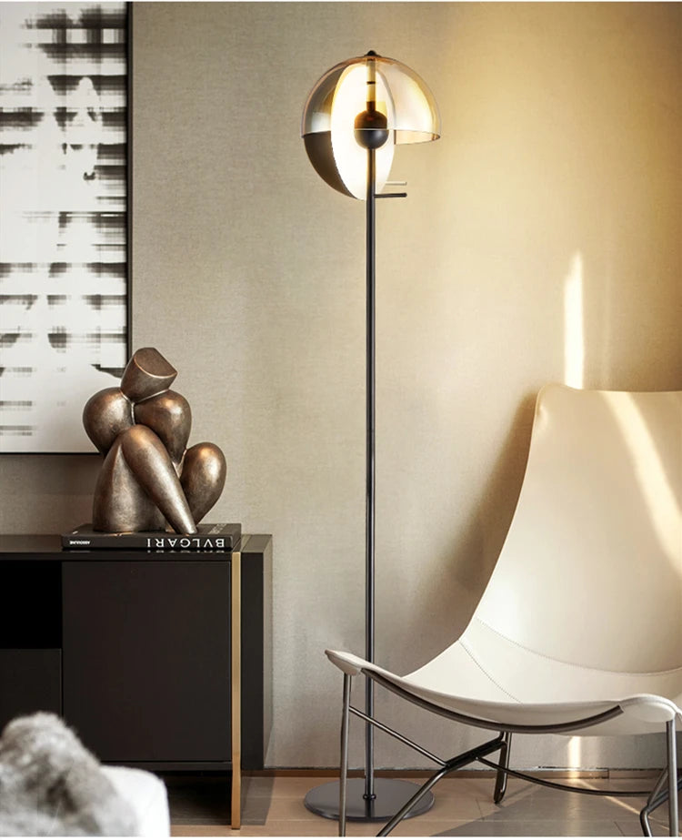 Lunar Visor Floor Lamp with smoked glass globe and warm amber inner diffuser illuminating a sophisticated living room with sculptural bronze decor, designer statement lighting by Domus Collective.