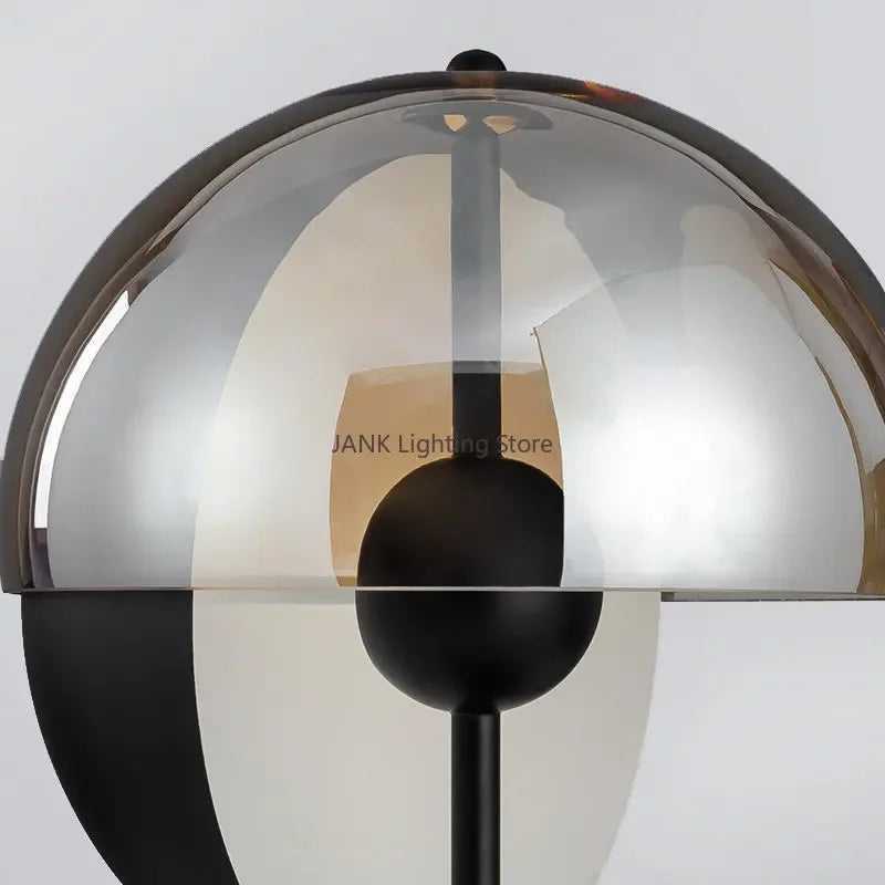 Close-up detail of the Lunar Visor Table Lamp revealing layered smoked glass hemispheres with warm golden interior and matte black spherical accent, precision crafted by Domus Collective.