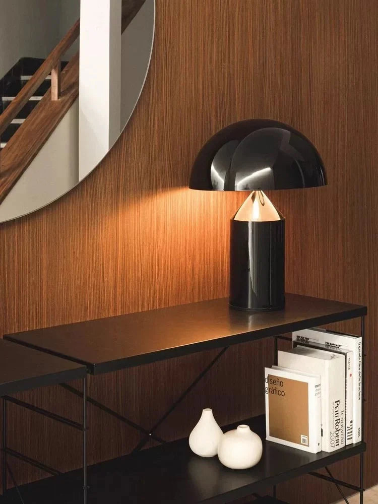 Lustrous Dome Table Lamp in high-gloss black with warm underlighting on a walnut console, its sculptural dome silhouette complementing mid-century modern design elements and curated books.