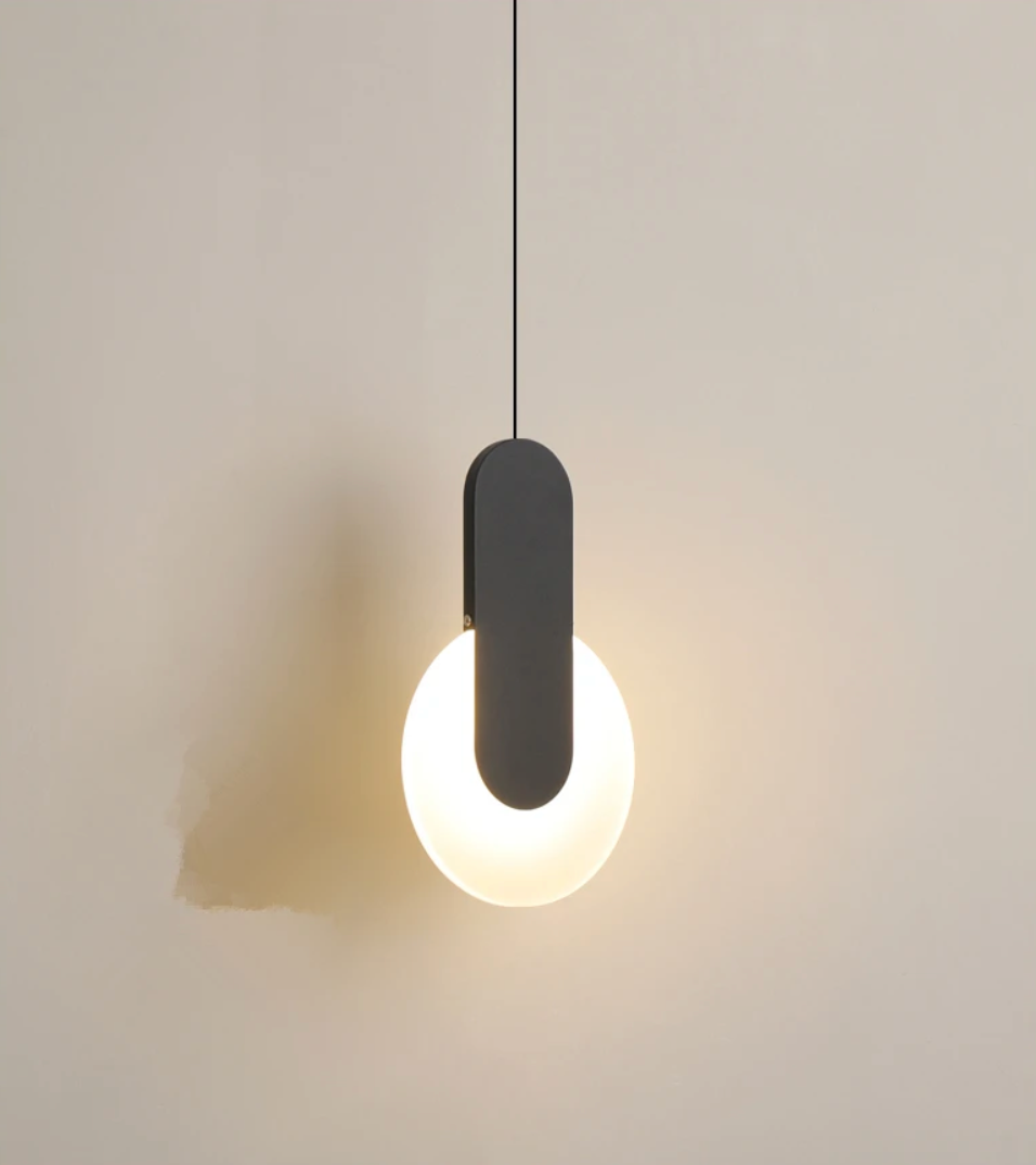Sculptural matte black pendant with frosted glass globe, the Matchstick Slice Light delivers artful minimalism and inviting ambient radiance for contemporary interiors, by Domus Collective.