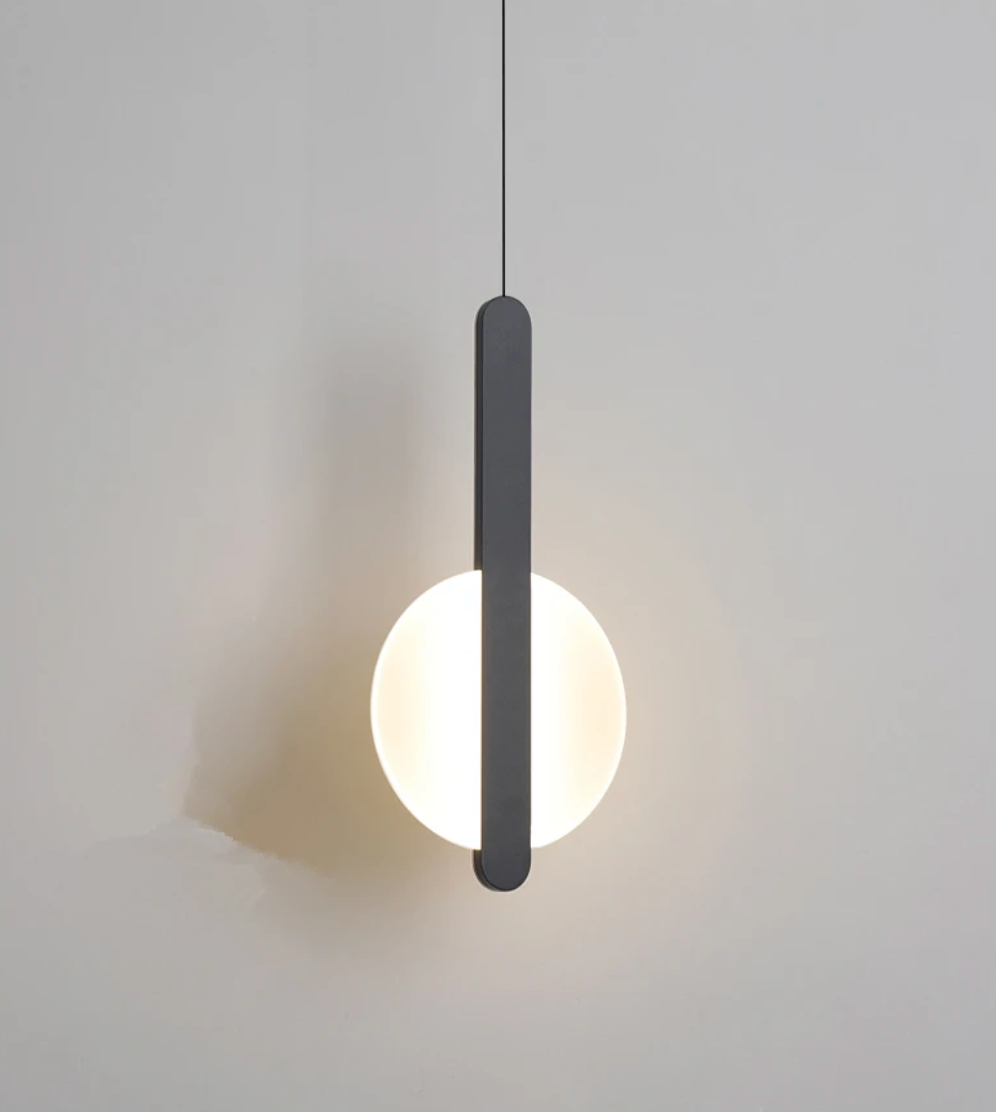 Frosted glass sphere bisected by an elegant dark metal stem, the Matchstick Slice Pendant Light brings architectural sophistication and soothing warmth to any room, by Domus Collective.