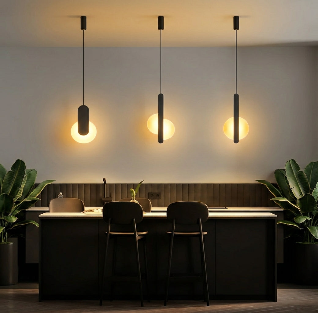 Contemporary elegance defined in the Matchstick Slice Pendant Light, featuring a slim metal profile intersecting frosted glass orbs that emit a gentle, diffused glow, by Domus Collective.