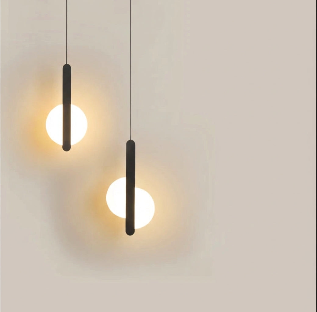 Matte black metal meets frosted glass in the Matchstick Slice Pendant Light, a streamlined silhouette delivering understated sophistication and calming ambient illumination, by Domus Collective.