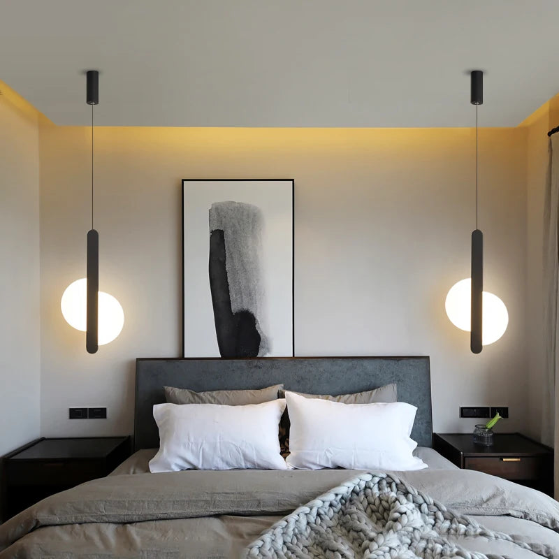 Matchstick Slice Pendant Lights flanking a contemporary bed frame, their warm frosted globes and sleek black bars adding sculptural balance to elevated bedroom design, by Domus Collective.