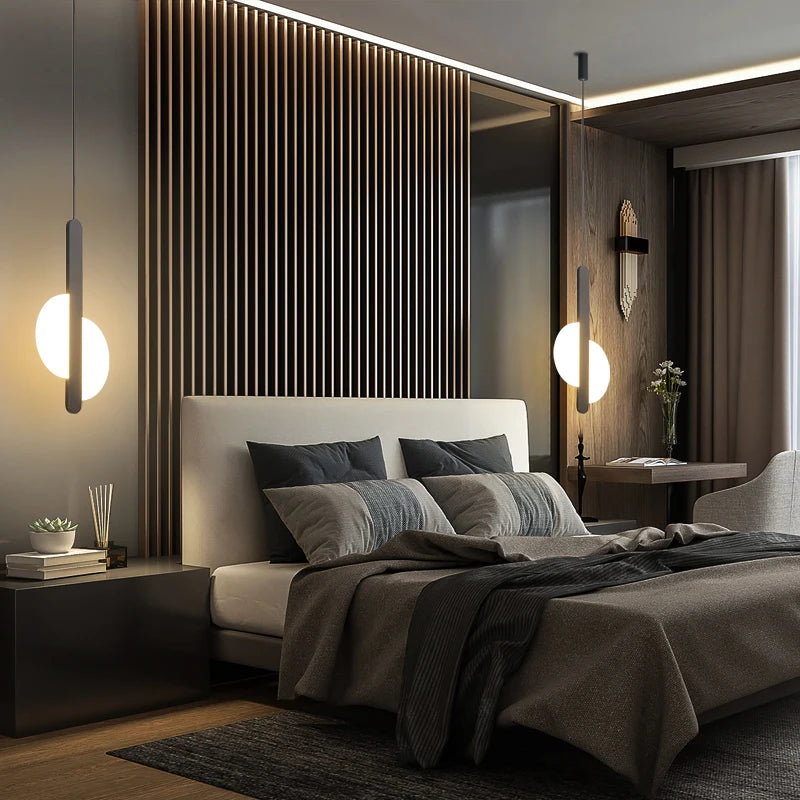 Luxurious bedroom lighting with the Matchstick Slice Pendant, its elongated metal form and soft spherical glow complementing rich textures and modern architectural details, by Domus Collective.
