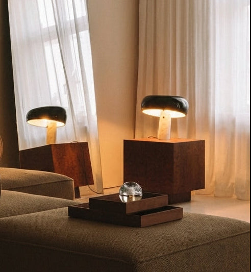 Mushroom Beam Table Lamp with black glass dome and cream marble base reflected in a full-length mirror in a warm toned sophisticated living room, elegant ambient lighting by Domus Collective.