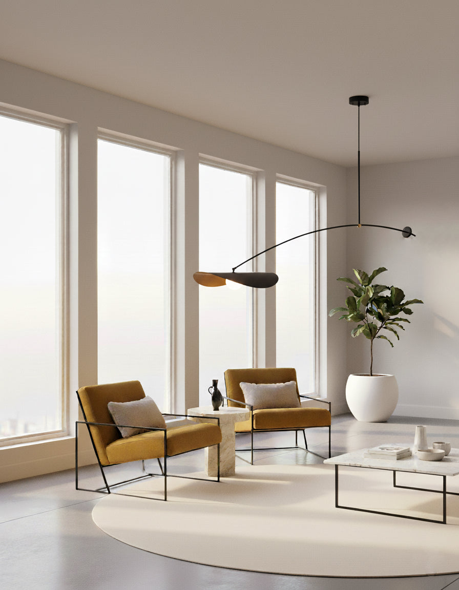 Sculptural ceiling pendant featuring organic petal shades in black and gold with frosted globe bulb, the Papilla Pendant Light anchors a sunlit minimalist living room with designer armchairs.