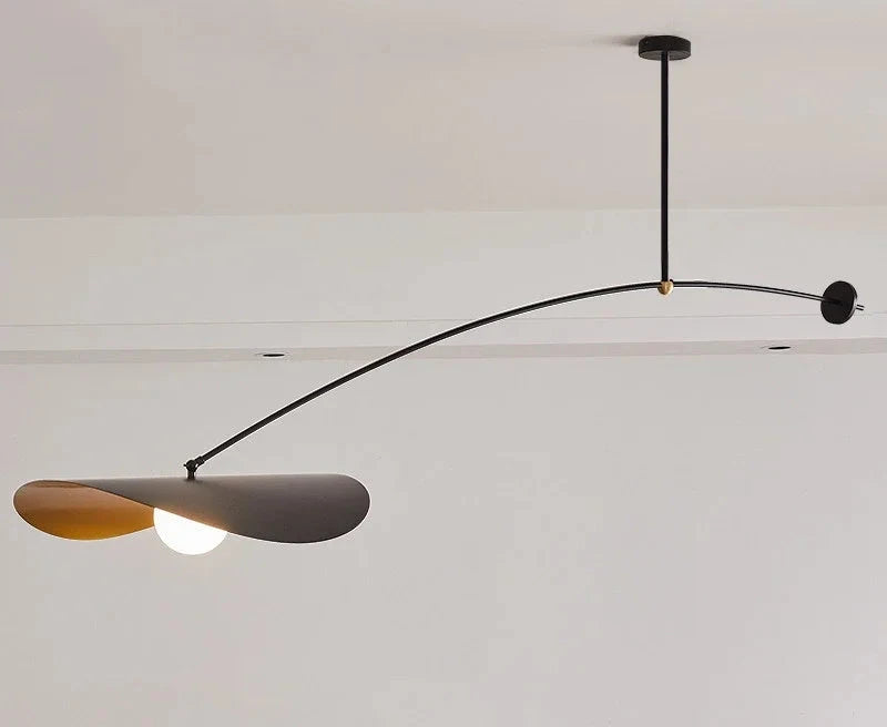 Full profile of the Papilla Pendant Light showcasing the balanced curved arm with counterweight disc and dual organic shades in black and gold finish with illuminated frosted glass globe.