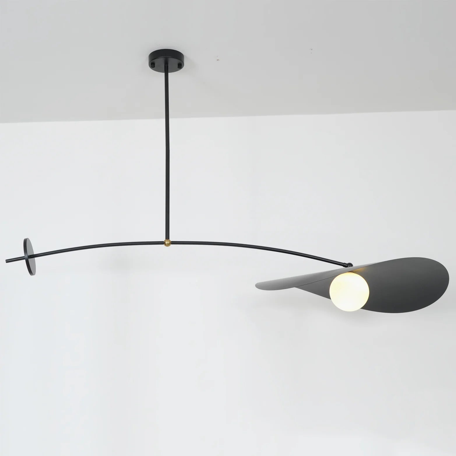Papilla Pendant Light in matte black featuring extended horizontal arm with dual counterbalance discs and butterfly petal shade, demonstrating the mobile-inspired sculptural design by Domus Collective.