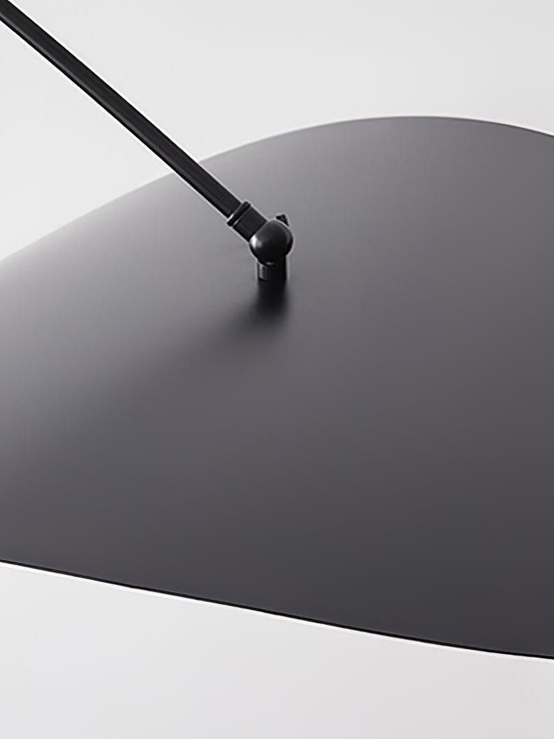 Detail of the Papilla Wall Lamp's matte blackorganic shade and precision ball joint connection to the curved arm, highlighting the sculptural engineering and smooth metal finish.