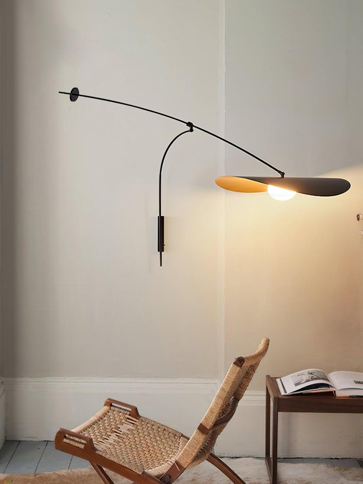 Full profile of the Papilla Wall Lamp showing dramatic arched arm with counterbalance disc and nature-inspired double shade in black with golden interior, providing graceful task lighting by Domus Collective.