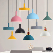 A curated display of the Pastel Rainbow Pendant Light collection featuring playful shades in mustard yellow, blush pink, sky blue, teal, and soft gray, each with brass accents for cheerful Scandinavian-inspired interiors, by Domus Collective.